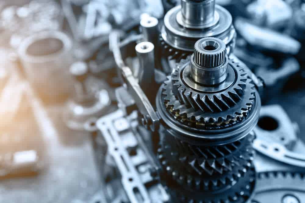 Close-up of a mechanical gearbox showcasing interlocking gears and cogs. The image emphasizes the complexity and precision of the machinery with a metallic shine and detailed engineering components, akin to those needed in Auto Repair Clarke County. The background is blurred, drawing focus to the gears.