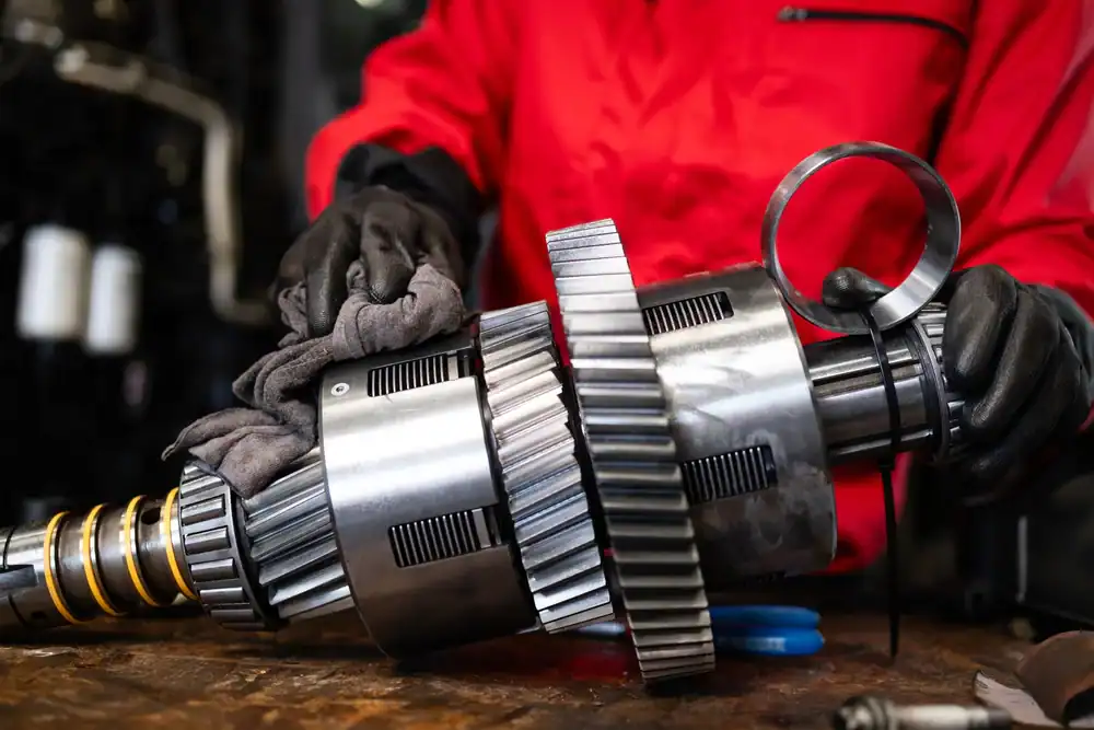 Skilled technician polishing metal gears in Clarke County, Georgia, ensuring precision and quality for Pro Transmission services